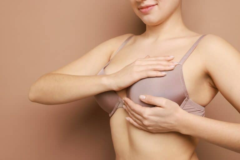 woman posing in bra holding her breast